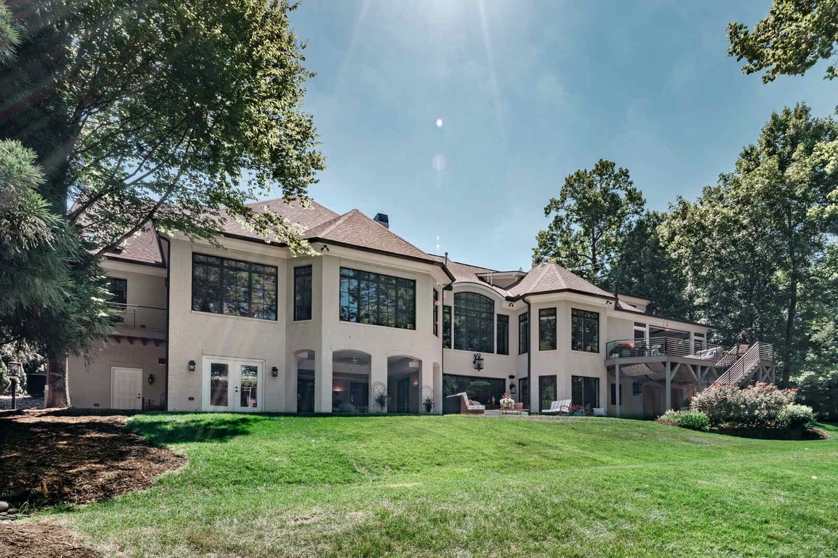 Rear view of a custom-built home by Wolfe Homes in Greensboro, NC, showcasing expansive windows and lush lawn