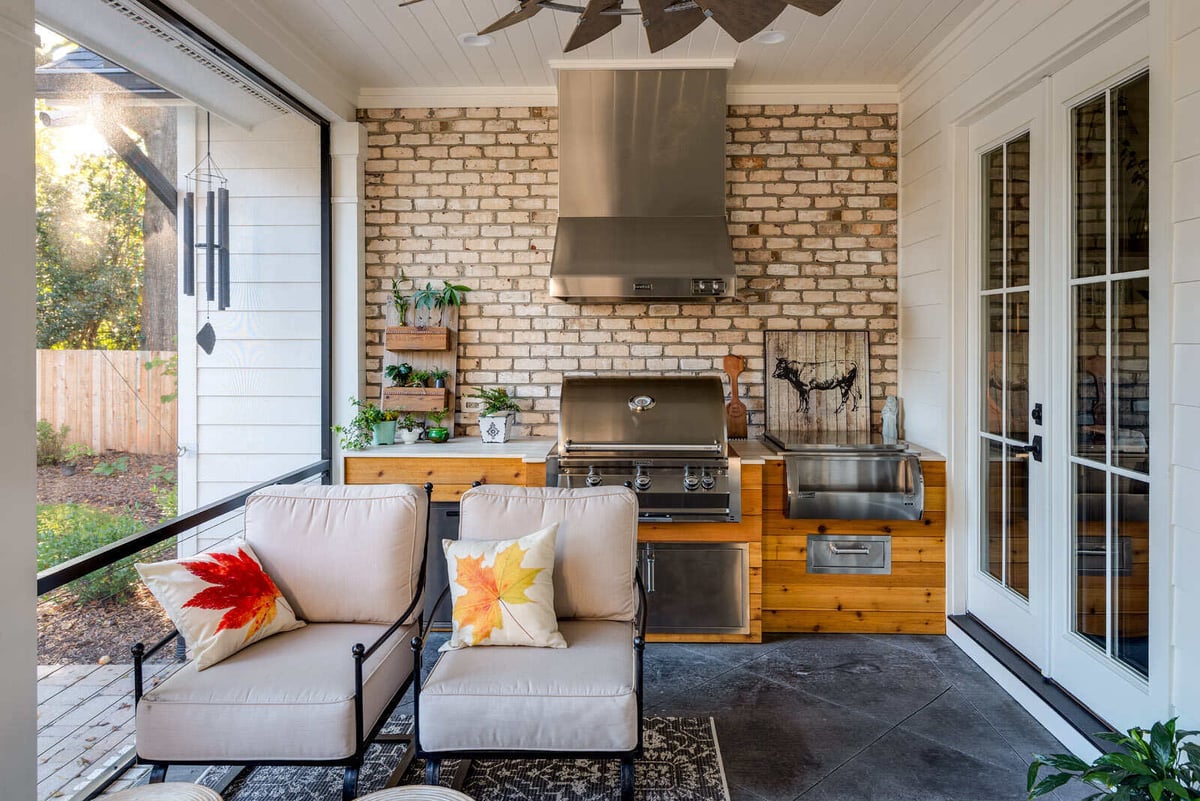 Custom screen porch in Greensboro remodel by Wolfe Homes with outdoor kitchen and cozy seating area