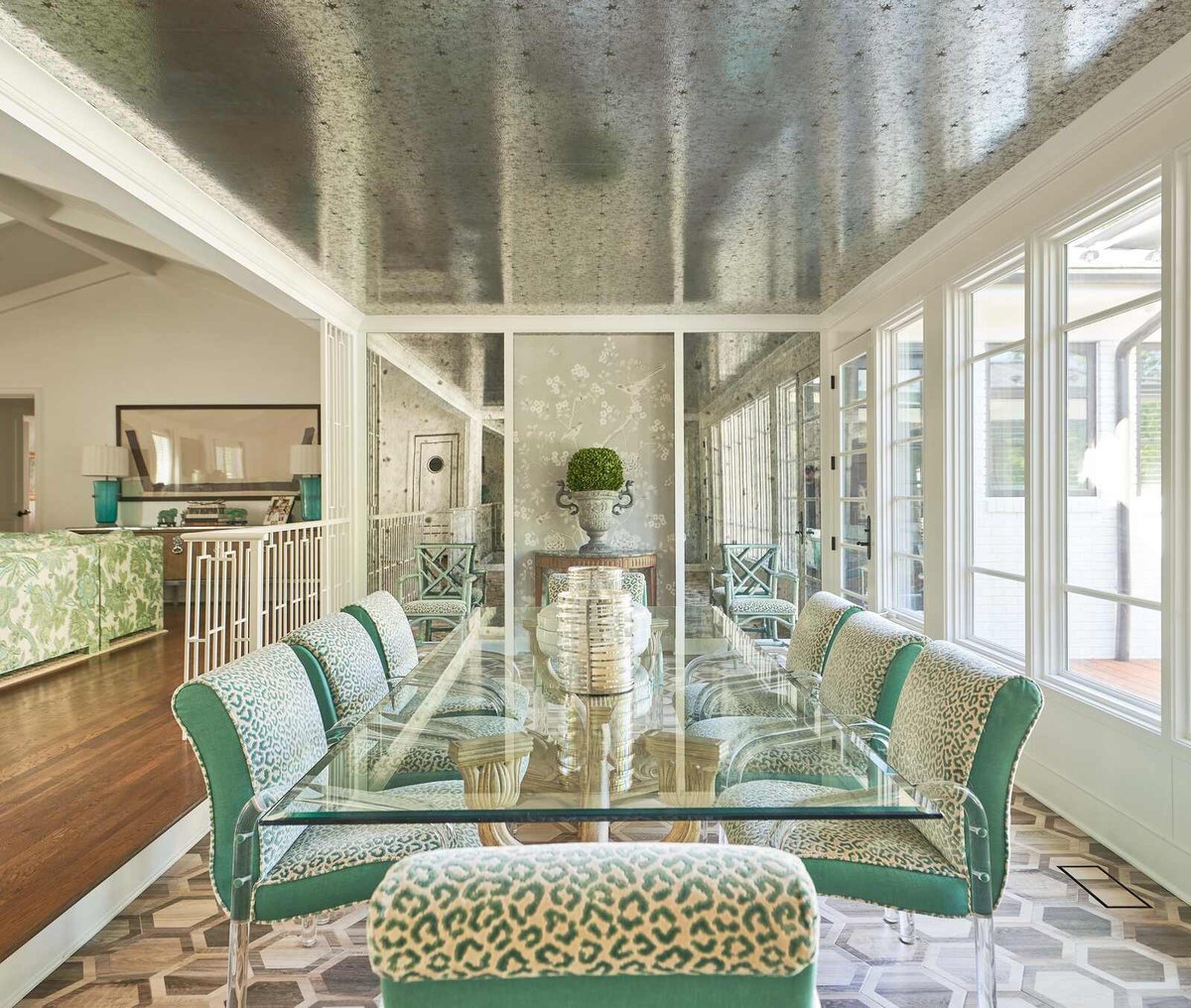 Elegant dining room with mirrored ceiling and plush green seating
