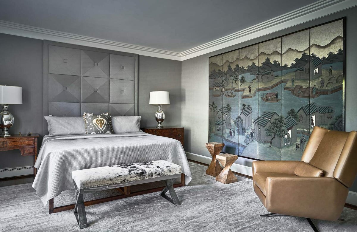 Modern bedroom with large decorative mural and leather accent chair