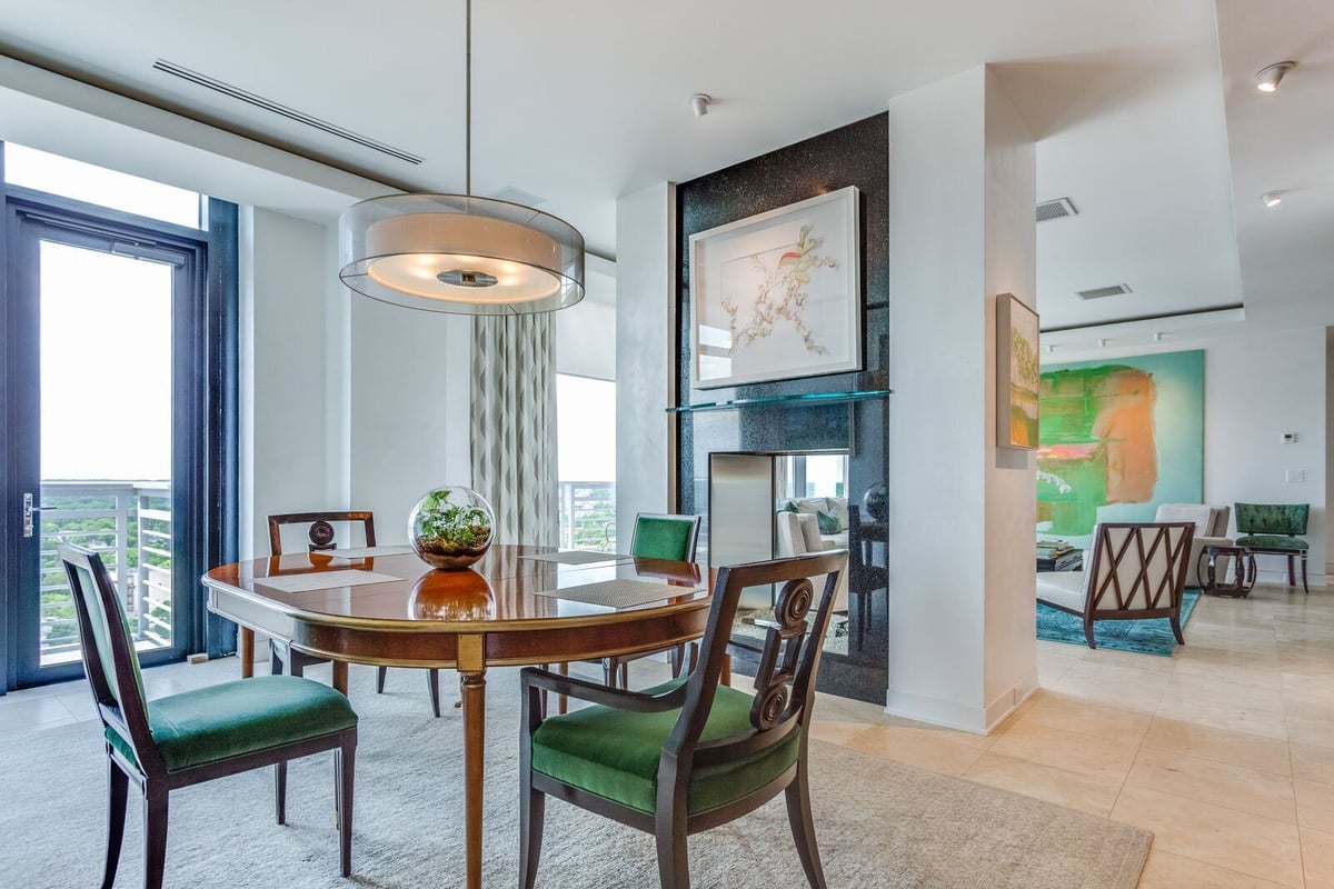 Dining area with green upholstered chairs and a chic table in a custom home by Wolfe Homes, Greensboro, NC
