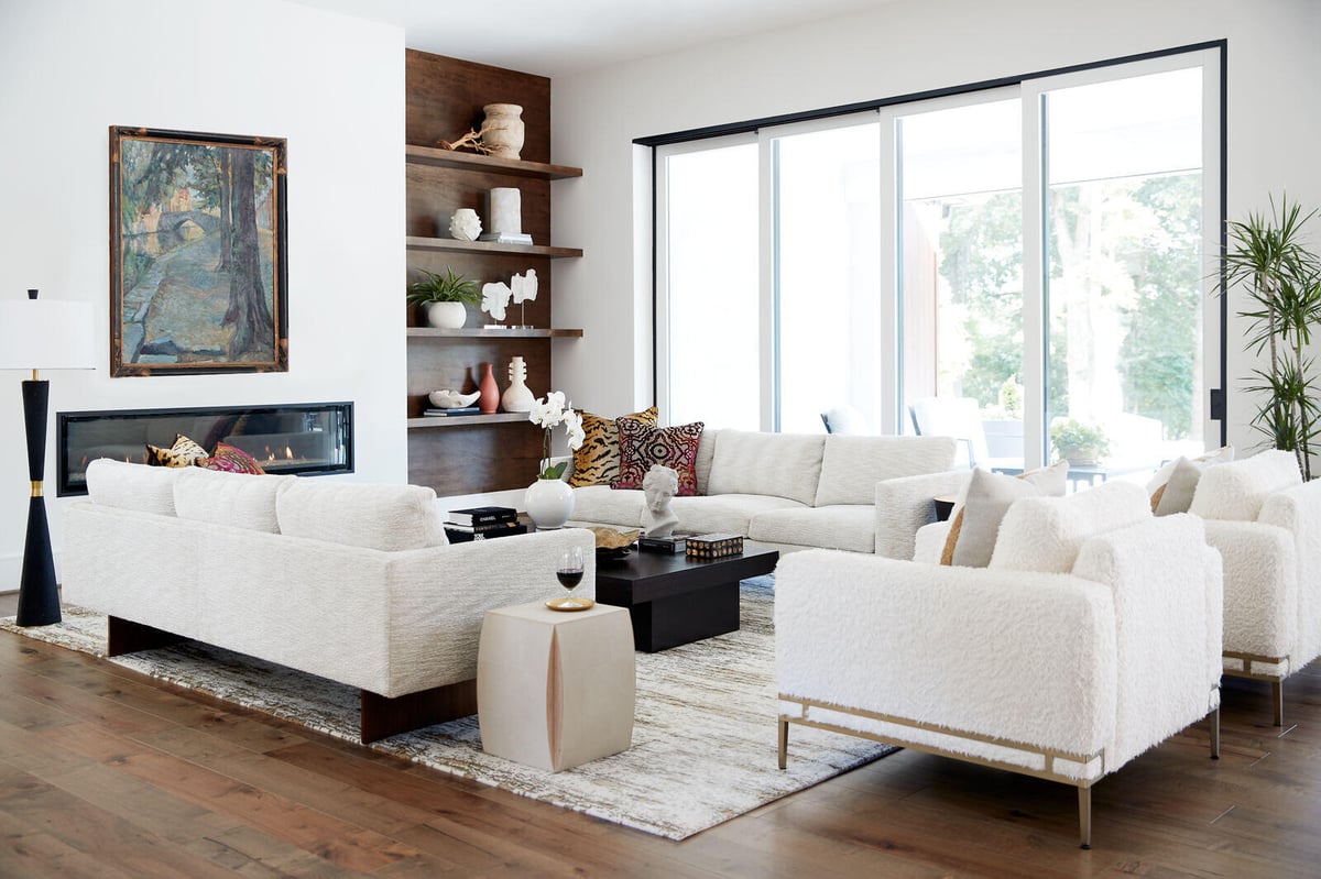 Bright living room with white seating and a fireplace, designed by Allen & James in Gaston County