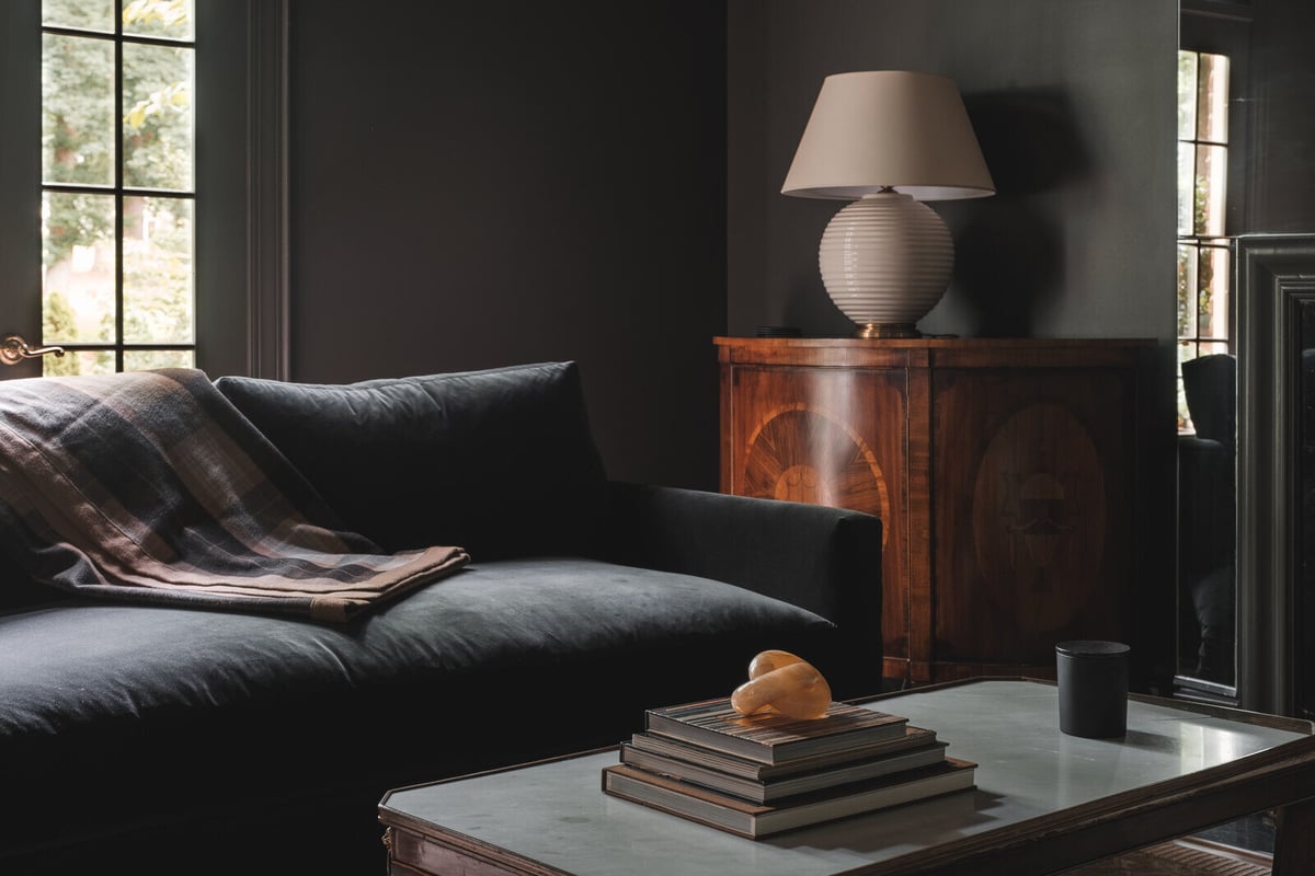 Comfortable seating area with dark couch and plaid blanket, part of a Greensboro custom remodel by Wolfe Homes
