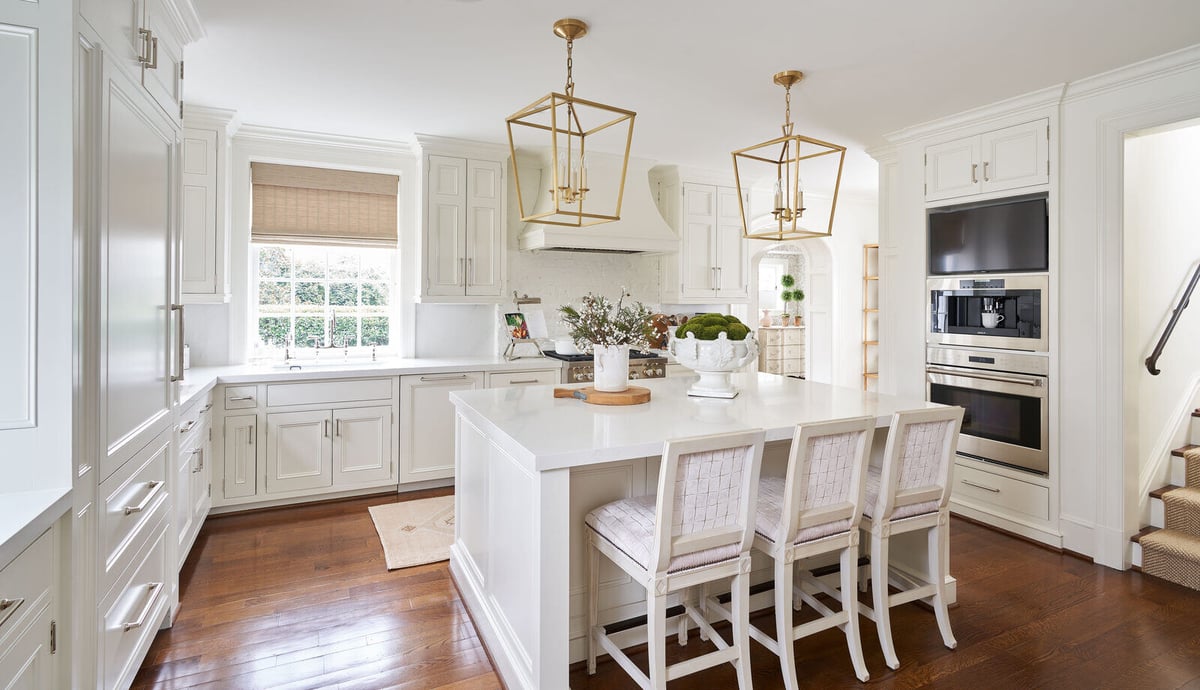 Bright kitchen with island seating and elegant lighting in a custom remodel by Wolfe Homes, Greensboro, NC