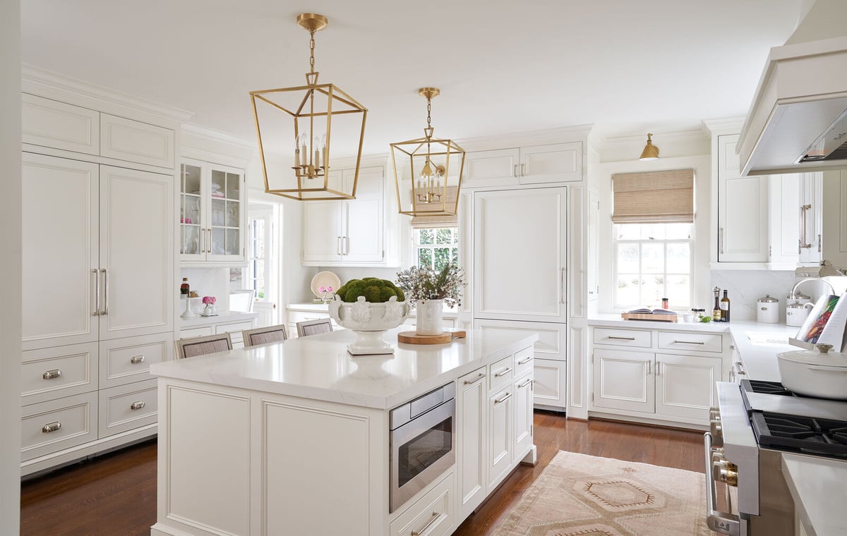 Spacious white kitchen with gold pendant lights in a custom remodel by Wolfe Homes, Greensboro, NC