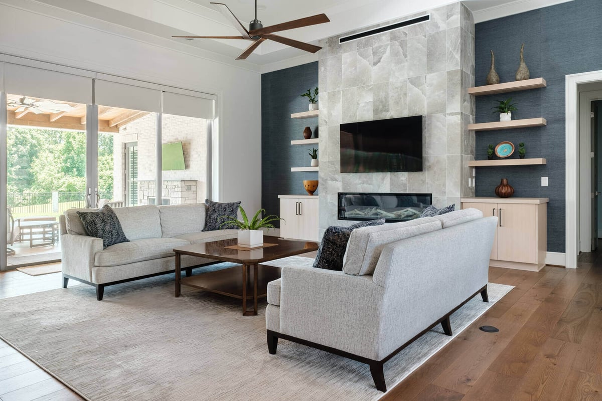 Cozy living room with fireplace and large windows in a Greensboro custom home by Wolfe Homes