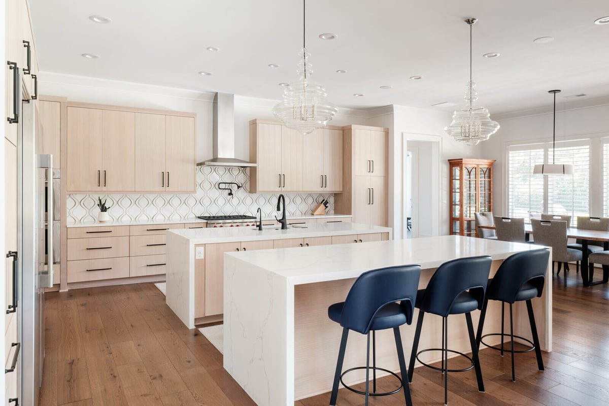 Open kitchen and dining area in a Greensboro custom home by Wolfe Homes with modern finishes