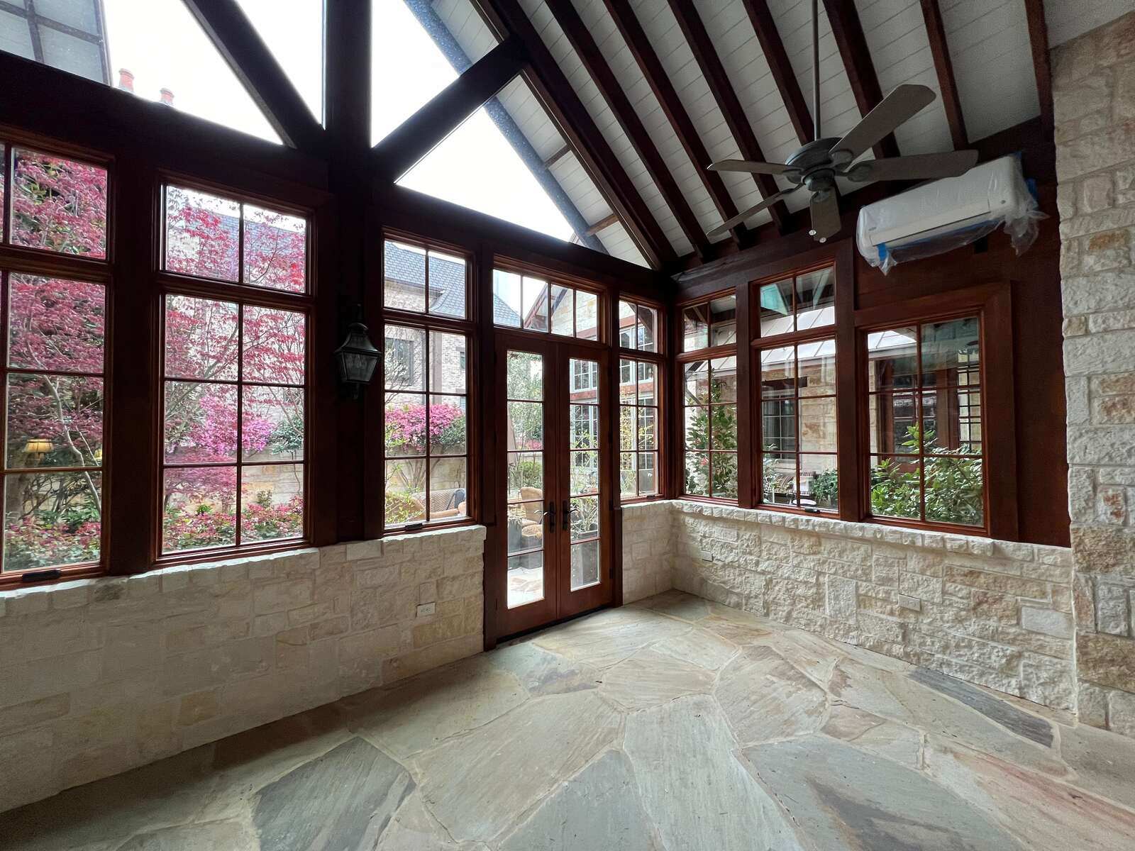 Sunroom with stone flooring and garden views by Wolfe Homes in Greensboro, NC