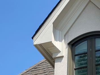 Corner of a dormer window that features signs of wood rot and damage