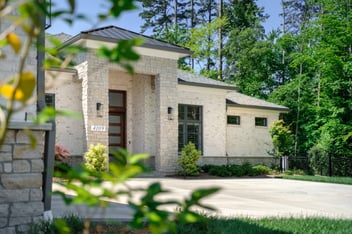 Beautiful custom home with large windows and front door, grand entrance, natural white stone exterior